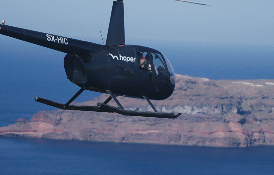 A black helicopter flying over a body of water.

Description generated by AI