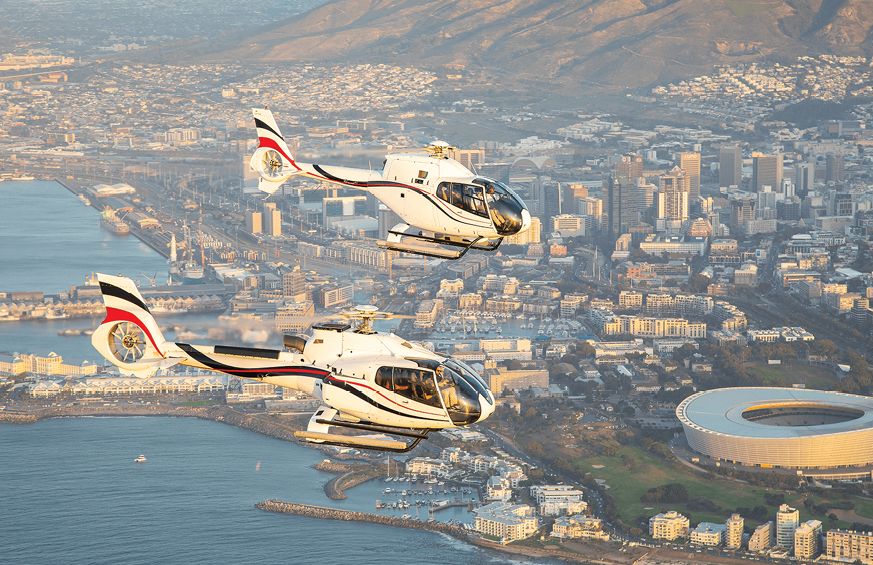 Two helicopters flying over a city.

Description generated by AI